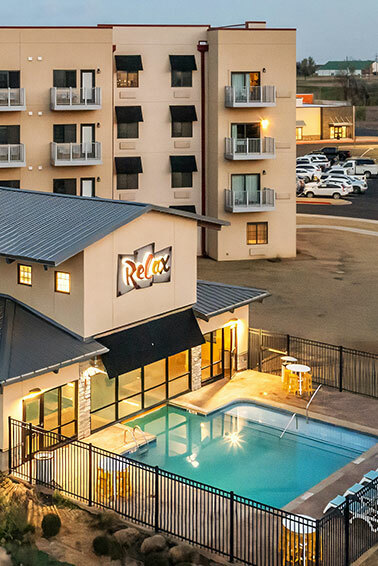 Outdoor swimming pool with lounge chairs at Broken Arrow Tulsa hotel